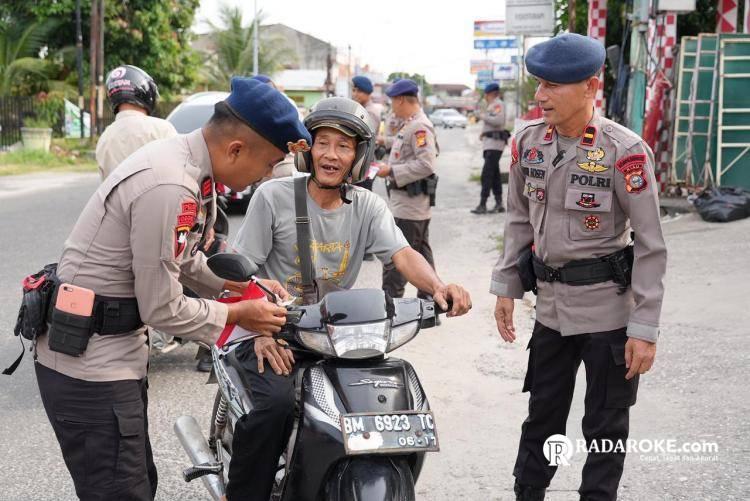 Brimob Polda Riau Bagikan Bendera Merah Putih ke Masyarakat